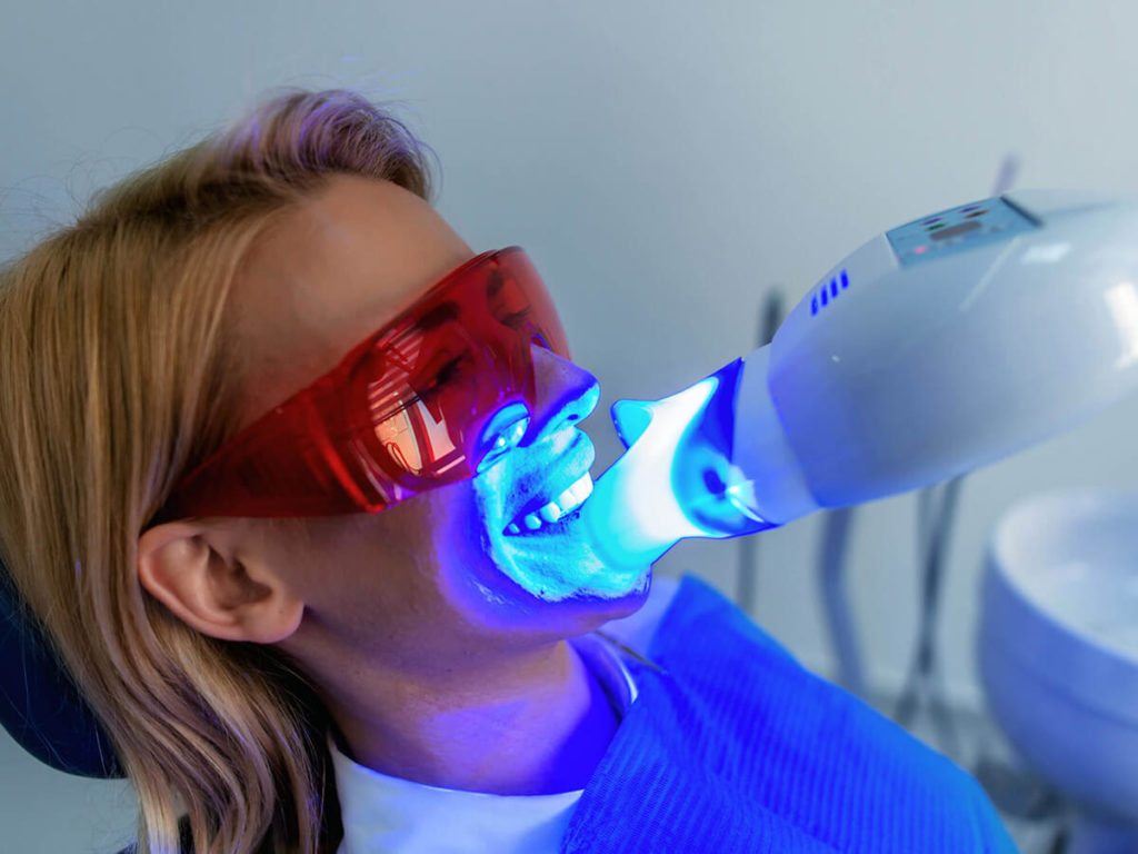 photo of women getting teeth whitened in dental chair