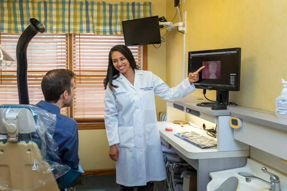 Dr. Katrina Verendia of lafayette dental in lafayette, nj talking to patient about xray on screen