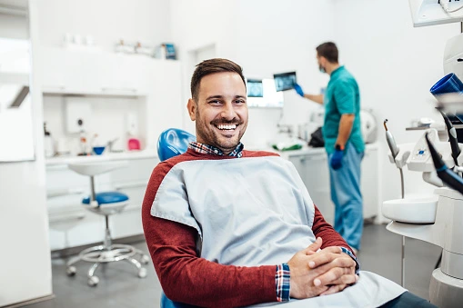 A man sitting on a dental chair during a dental implant consultation